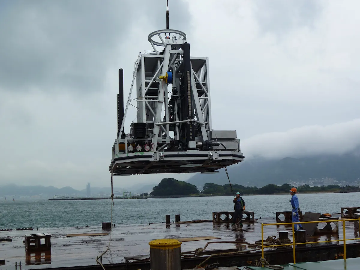 Wassoc's subsea lander drill utilizing wireline coring technology suspended by crane over water during test deployment